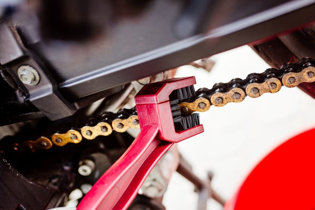 Brossage chaîne moto avec brosse 3 faces après application du dégraissant WD-40